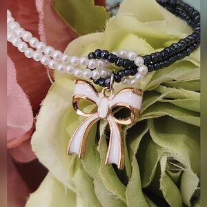 Bracelet black and white beads with a ribbon charm